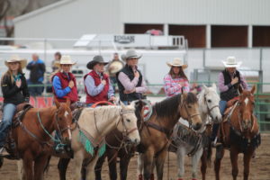 Riders from the Wyoming Club salute the flag at the high school rodeo in Afton.