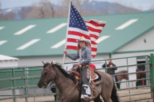 Maddie Hale, Idaho District 8 Rodeo Queen, carries the American flag  during the opening ceremonies of the high school rodeo on Saturday, May 14th.