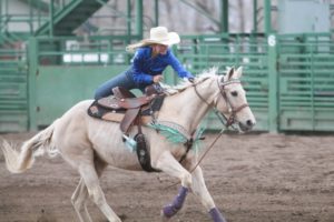 Brooklyn Brown of Afton dismounts her horse as she competes in the goat tying event at Saturday's high school rodeo.