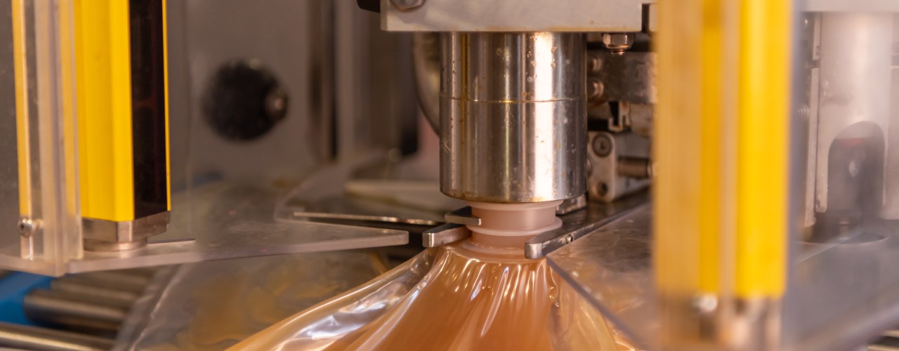 Apple juice going into an automatic bagging system for easy transport and packaging. The bag is attached to the juice drop.