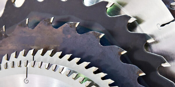 A line-up of saw blades of various sizes and shades of grey. The saws decrease in size as the stack progresses.