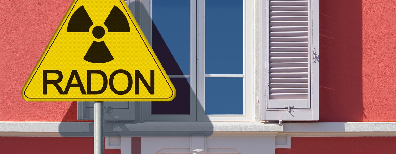 The exterior of a home with coral paint, windows, and shutters, with a large triangular yellow sign that says "RADON."