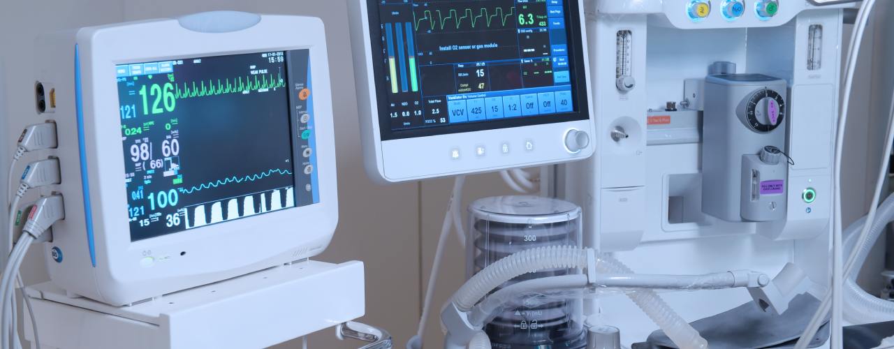 Hospital patient monitoring and ventilator equipment displaying vital signs, heart rate, and respiratory data.