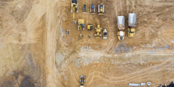 An aerial view of empty land and heavy machinery sitting on the land. Each piece of equipment serves a purpose.