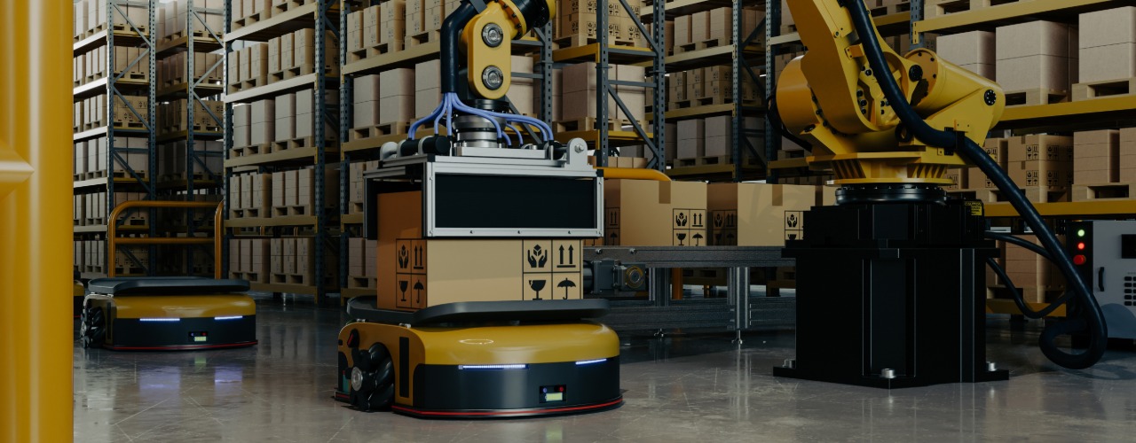 A yellow robotic arm is handling cardboard boxes on carts. Tall shelves are stocked with products in the background.