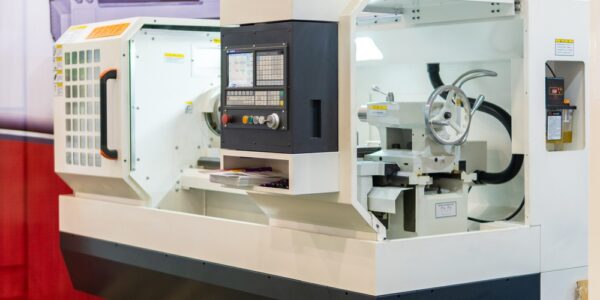A large CNC machine is black and white. It has large windows to observe the inside of the machine.